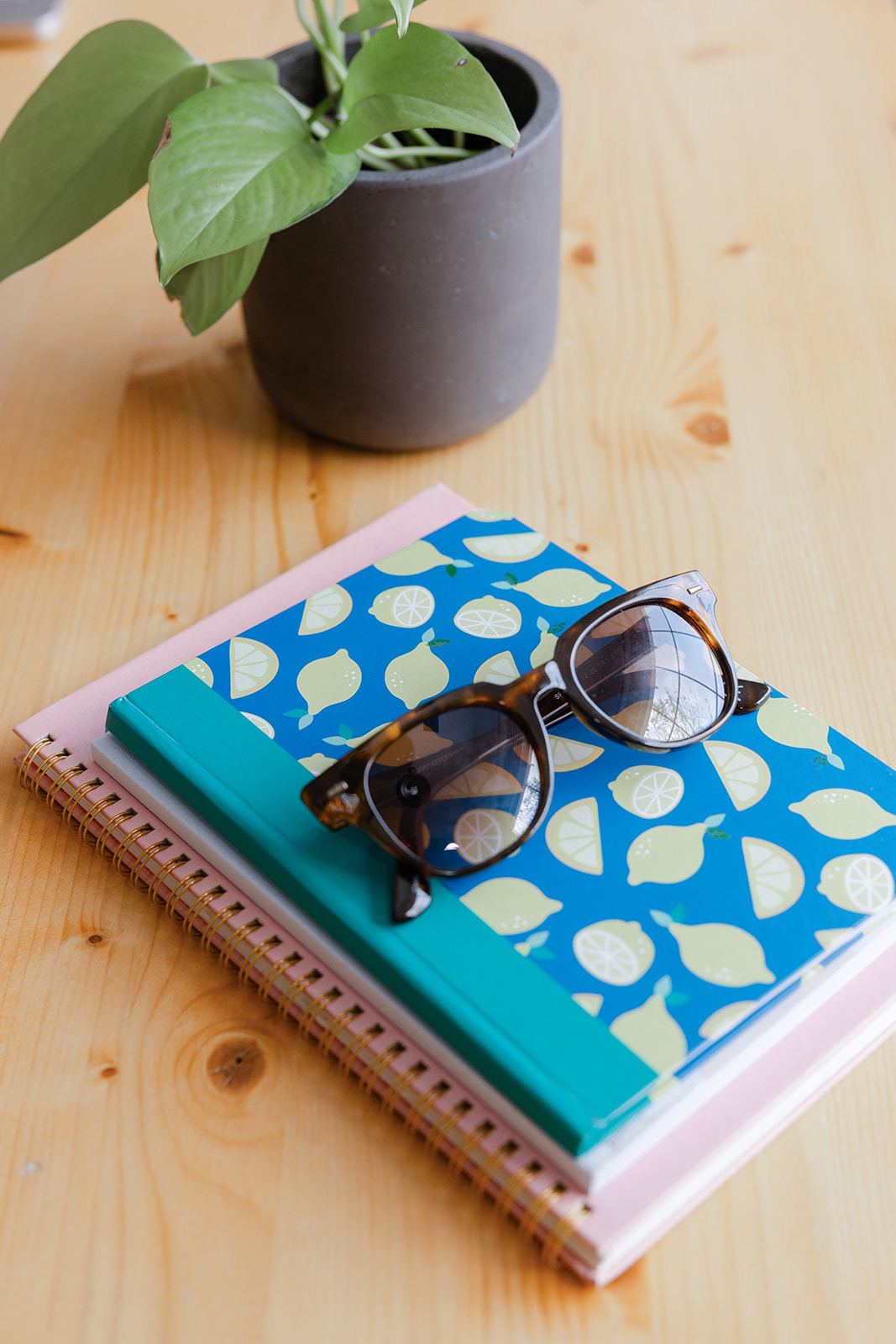 Notebooks and sunglasses on a wooden desk, ready for an Office Jam session